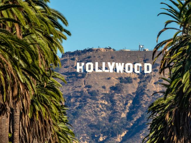 EMBARGO FOR TWAM, 19 APRIL 2025. FEE MAY APPLY. 19 october 2018 - Los Angeles, California. USA: Hollywood Sign between Palm trees from central Los Angeles