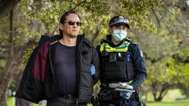 A man is detained by members of Victoria Police during a protest near Government House on August 31, 2021 in Melbourne, Australia. (Photo by Darrian Traynor/Getty Images)