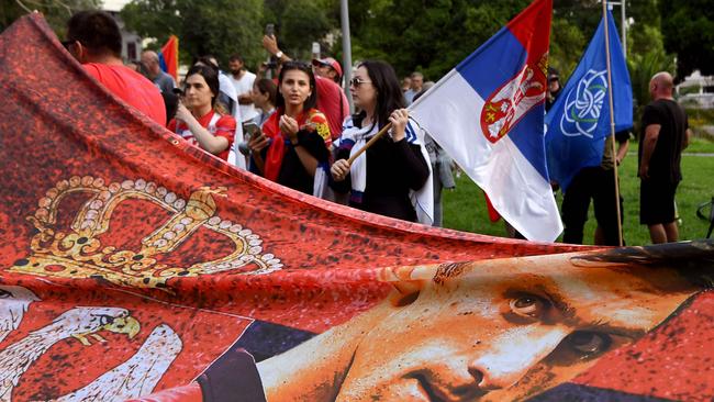 Members of the local Serbian community hold flags and banners outside a government detention centre where Serbia's tennis champion Novak Djokovic is staying in Melbourne on January 8, 2022, after he was dramatically refused entry to Australia over his Covid-19 vaccine status. Picture: William WEST / AFP