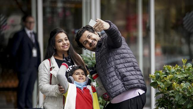 A happy family stops for a selfie after emerging from mandatory quarantine in Adelaide on Saturday. Photo: MIKE BURTON