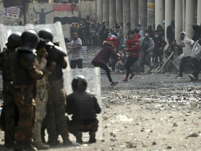 Riot police try to disperse anti-government protesters during clashes in Baghdad, Iraq as Mike Pence touches down with a surpise visit. Picture: AP Photo/Hadi Mizban