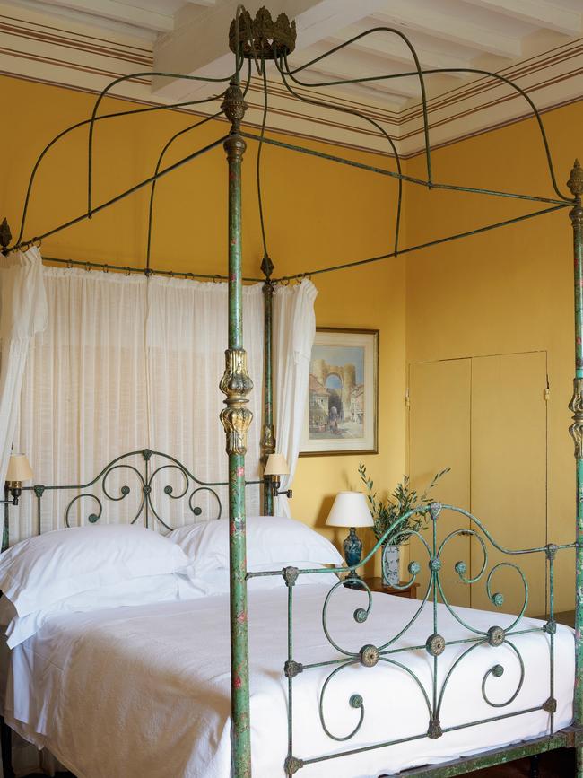 The Silver bedroom with a spindly canopy bed and bold marigold walls. Picture: Simon Upton