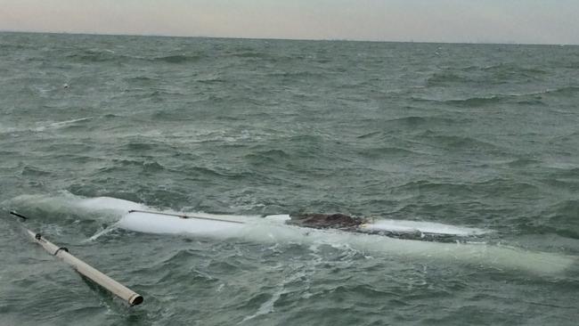 The remaining part of the capsized catamaran the sailors clung to. Pictures: NT Police