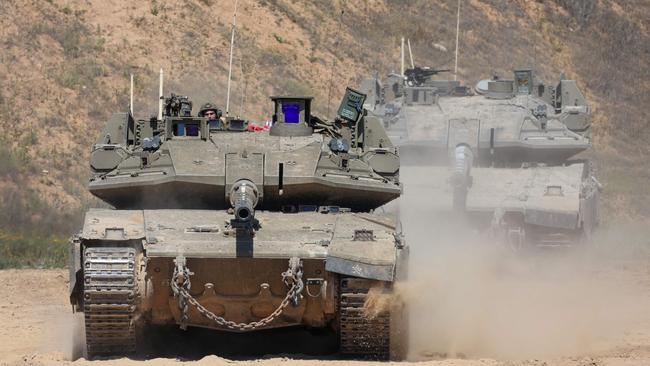 An Israeli soldier operates a tank at a position along Israel's southern border with the northern Gaza Strip on March 19, 2025. Israel on March 18 launched its most intense strikes on the Gaza Strip since a January 19 ceasefire with Palestinian militant group Hamas ended more than 15 months of war. (Photo by Jack GUEZ / AFP)