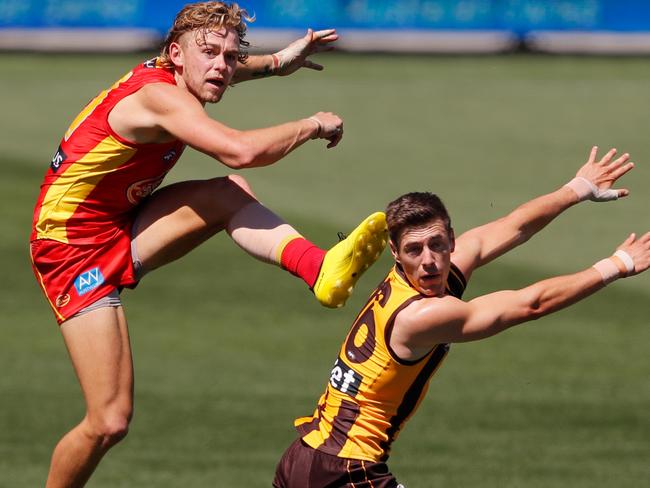 ADELAIDE, AUSTRALIA - SEPTEMBER 20: Hugh Greenwood of the Suns kicks the ball past James Cousins of the Hawks during the 2020 AFL Round 18 match between the Hawthorn Hawks and the Gold Coast Suns at Adelaide Oval on September 20, 2020 in Adelaide, Australia. (Photo by Matt Turner/AFL Photos via Getty Images)