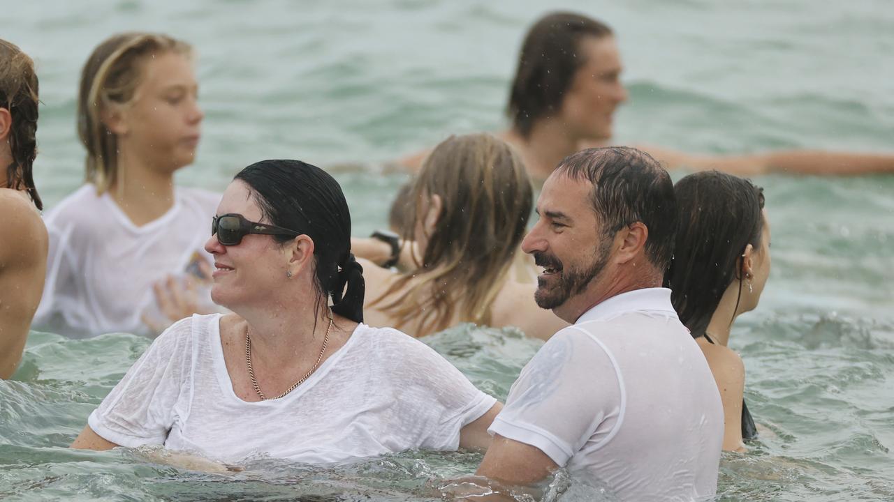 Balin Stewart’s parents Kerri-Lyn and Michael watch on as friends and family swim at their son’s home beach at Buddina. Picture: Lachie Millard