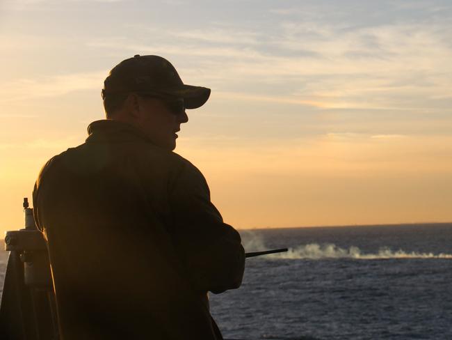 Brad A. Fancher, commanding officer of the dock landing ship USS Carter Hall, observes the debris field. Picture: AFP