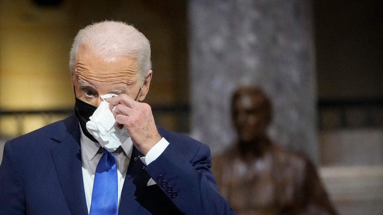 US President Joe Biden wipes his eyes as Vice President Kamala Harris delivers remarks on the one year anniversary of the January 6 attack on the US Capito.
