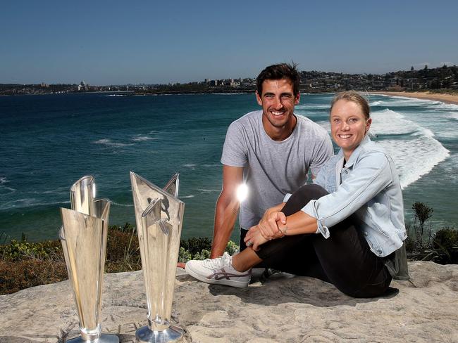 Australian husband and wife cricketers Mitchell Starc and Alyssa Healy with the women's and men's ICC T20 World Cup trophies.