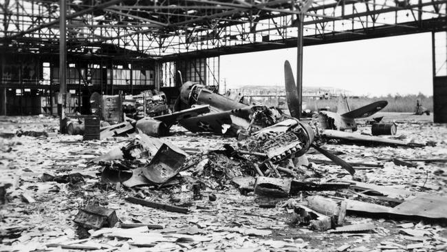 An Australian Wirrway plane (background) and American Kittyhawk (foreground) in a hangar after the Bombing of Darwin