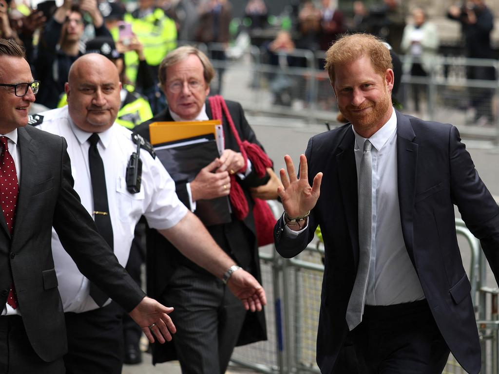 Britain's Prince Harry waves to fans as he arrives at the High Court. (Photo by Adrian DENNIS / AFP)