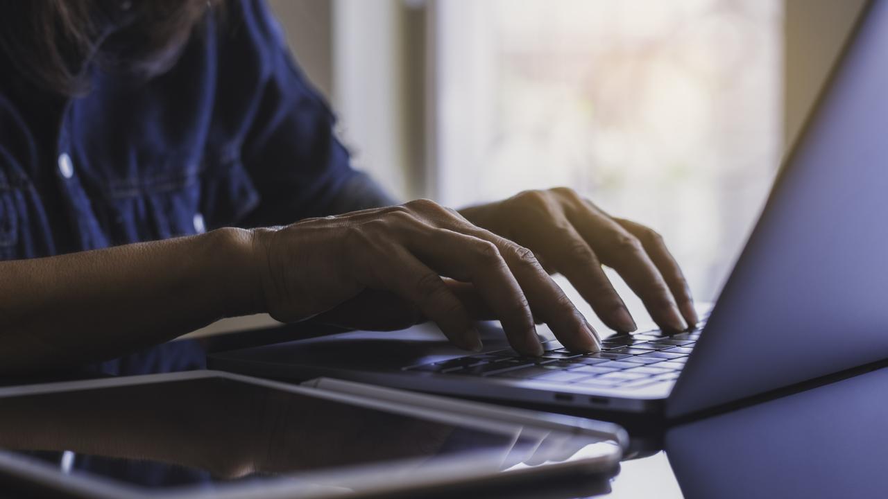 Close-up woman's hands work and typing on laptop computer with digital tablet on the desk at workplace.