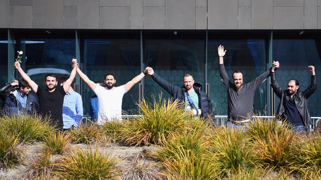 Al Noor Mosque shooting survivors Mustafa Boztas, left, Wasseim Alsati and Temel Atacocugu celebrate as they leave Christchurch High Court on Thursday. Picture: Getty Images