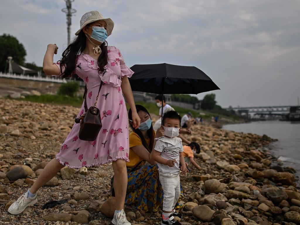 A woman wearing a face mask with her child in Wuhan. Picture: Hector RETAMAL / AFP.