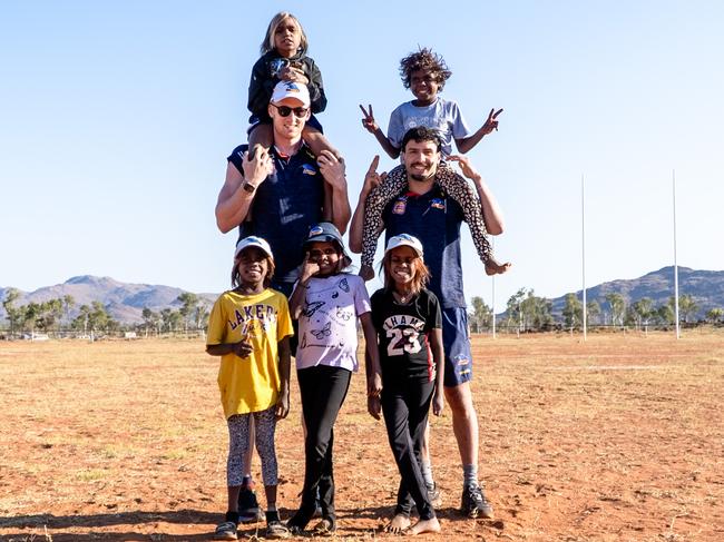 Adelaide’s Izak Rankine and Reilly O’Brien with kids in the APY Lands. Picture: AFC