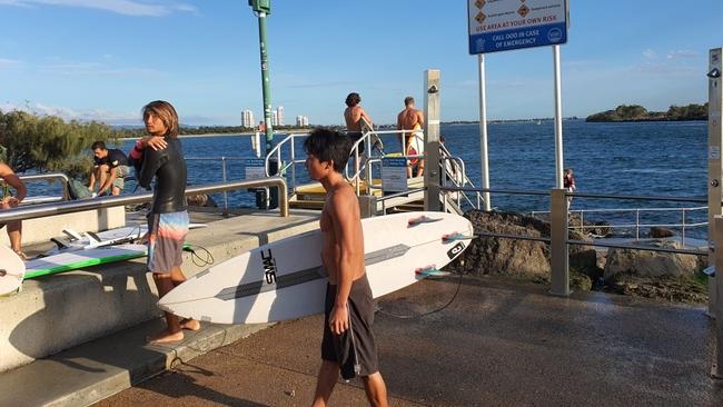 Surfers at The Spit, Main Beach, making the most of good conditions – despite outdoor trips being limited to “essential” only.