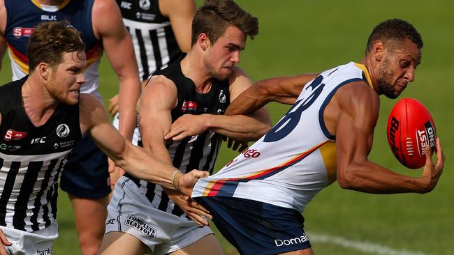 Cameron Ellis-Yolmen of the Crows tackled by Anthony Biemans and William Snelling of Port. Picture: Matt Turner.