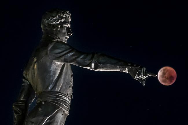 Blood Moon last night in Adelaide with the Colonel Light Statue. Picture: Steven Genesin