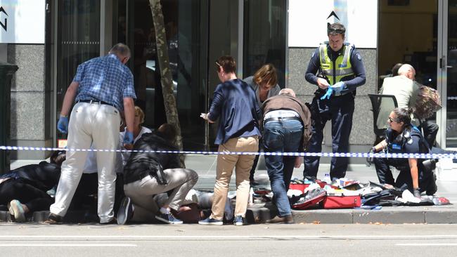 Pedestrians lay on Bourke St after being hit by the car. Picture: Tony Gough