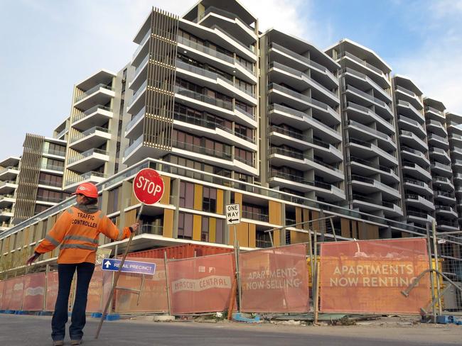 This photo taken on June 17, 2016 shows a worker holding a stop sign in front of an apartment block under construction in Sydney. Sydney is imposing new taxes on foreigners buying homes amid growing concerns that a flood of mostly Chinese investors is crowding out locals and killing the "Great Australian Dream" of owning property. / AFP PHOTO / WILLIAM WEST / TO GO WITH Australia-China-property-tax,FOCUS by Glenda KWEK