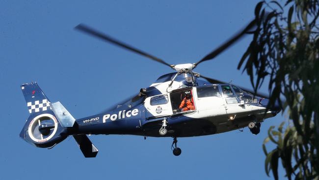 The police chopper searching above the forest. Picture: David Crosling