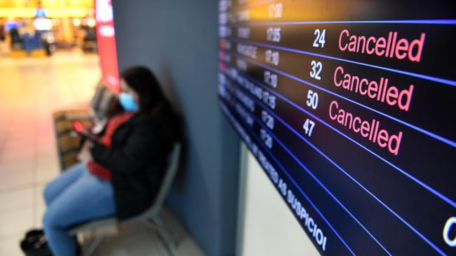 An arrivals board shows cancelled flights at Brisbane airport's domestic terminal. An airport worker recently tested positive to coronavirus. Picture: NCA NewsWire / Dan Peled