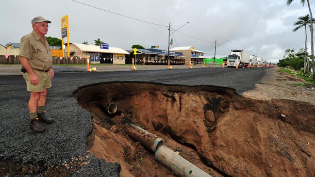 Heavy rain from ex cyclone Oswald caused a big washout along part of the Bruce Highway at roadworks at Cardwell. Cardwell resident Les Harris looks at the damage – a collapsed section of road in Cardwell's main street. A crater almost 2m deep has occurred following heavy rain.