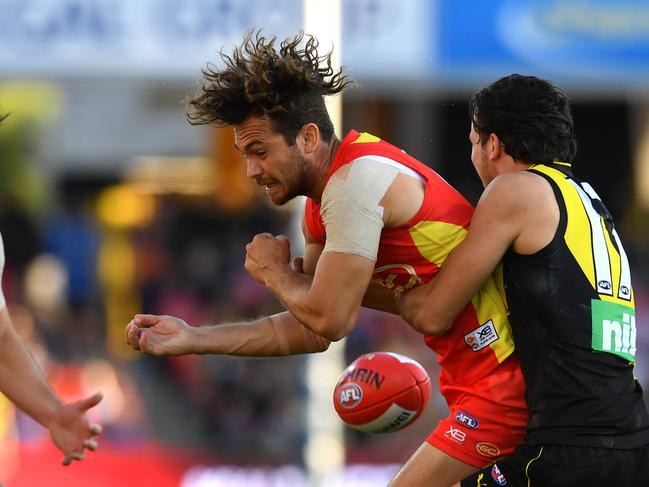 Jarrod Harbrow of the Suns (left) is tackled during the Round 21 AFL match between the Gold Coast Suns and the Richmond Tigers at Metricon Stadium on the Gold Coast, Saturday, August 11, 2018. Picture: AAP Image/Darren England