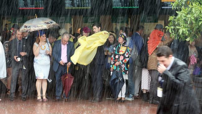 Crowds hide from the saturating rain. Picture: Alex Coppel