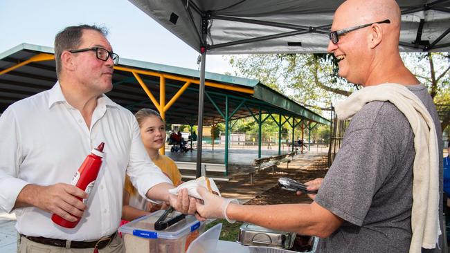 VOICEREF23 Solomon MP Luke Gosling enjoys the Referendum sausage with Paul Eustance from school council for the Referendum on The Voice at Parap polling station, in Parap, NT. Picture: Pema Tamang Pakhrin