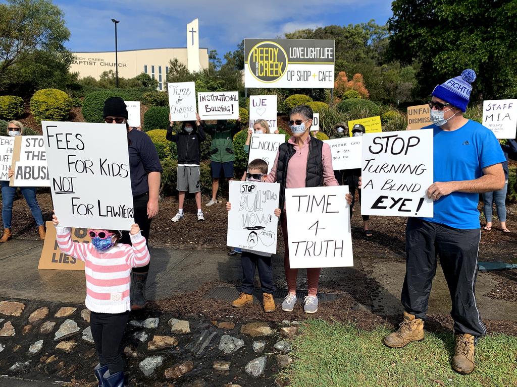 Placard-waving protesters wearing masks with the word ‘silenced’ have crashed the AGM of a troubled Gold Coast elite private school for what they say is ‘a last stand’.