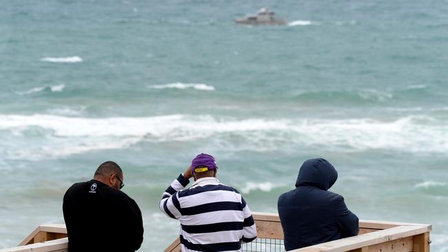 Jona Kinivuwai’s family wait at Number 16 Beach in Rye. Picture: Andrew Henshaw