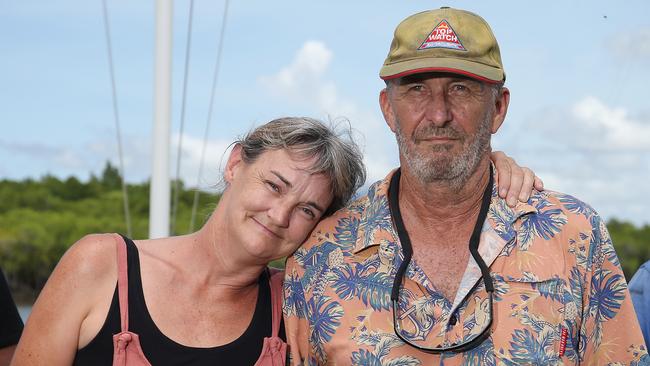 Cairns Cruising Yacht Squadron club members Dayna Russell and commodore John Stewart comfort each other in front of flags flying at half mast. Picture: Brendan Radke