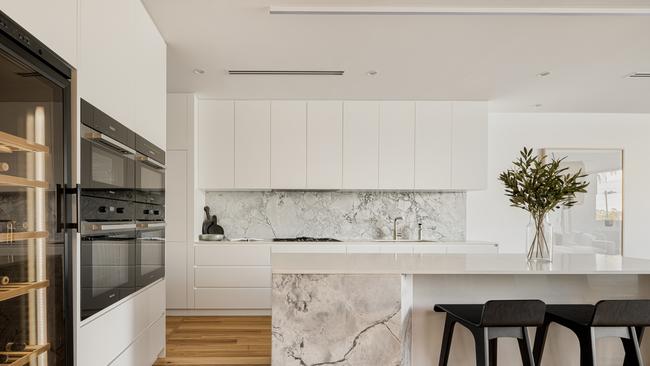 The luxurious chef’s kitchen at 72 Parkside Circuit, Hamilton includes natural stone features and custom cabinetry alongside Miele appliances, a fully integrated Liebherr fridge/freezer, a 195 bottle refrigerated wine cabinet, a Zip hydrotap, and a separate butler’s pantry. Photo: Arin Ozdemir