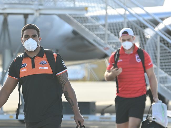 14/07/2021 : NRL teams the Tigers and Dragons arrive on a Virgin charter flight, then load onto buses behind fences at the Gold Coast airport , Coolangatta. The NRL has relocated all their teams to QLD ahead of an expected border closure due to the covid outbreak in NSW.  Lyndon Mechielsen/The Australian