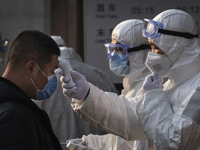 BEIJING, CHINA - JANUARY 25: A Chinese health worker checks the temperature of a woman entering a subway station during the Chinese New Year and Spring Festival on January 25, 2020 in Beijing, China. The number of cases of a deadly new coronavirus rose to over 1300 in mainland China Saturday as health officials locked down the city of Wuhan earlier in the week in an effort to contain the spread of the pneumonia-like disease which medicals experts have been confirmed can be passed from human to human. In an unprecedented move, Chinese authorities put travel restrictions on the city of Wuhan and neighbouring cities affecting a population of over 35 million. The number of those who have died from the virus in China climbed to at least 41 on Saturday and cases have been reported in other countries including the United States, Australia, France, Thailand, Japan, Taiwan and South Korea. (Photo by Kevin Frayer/Getty Images)