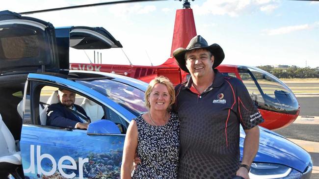 SCUBER SURPRISE: Gladstone couple Terry and Kym Purcell were the first paying customers to ride the scUber at Heron Island when it launched to the public yesterday. They are pictured next to the helicopter they took to the island and the official scUber Tesla driver Domenico Galluccio. Picture: Matt Harris