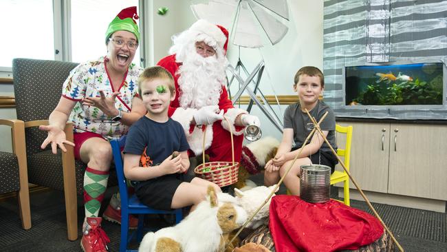 Stanthorpe brothers Jaspa (left) and Brax Ford meet Santa and his elf Paula McDonald as he visits St Vincent's Private Hospital, Friday, December 20, 2019. Picture: Kevin Farmer