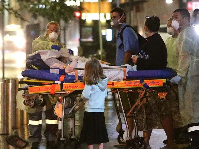 Three sick children are removed from the rear of the Hilton Hotel, Sydney. Pictures: Bill Hearne