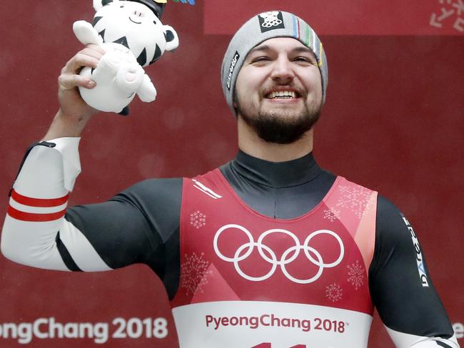 David Gleirscher of Austria smiles after getting a toy tiger for taking the bronze medal during the winner's ceremony of the men's luge competition at the 2018 Winter Olympics in Pyeongchang, South Korea, Sunday, Feb. 11, 2018. (AP Photo/Andy Wong)