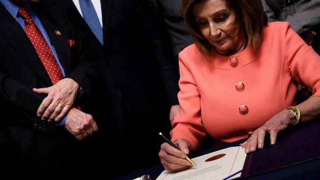 House of Representatives Speaker Nancy Pelosi signs the articles of impeachment of Donald Trump last week. Picture: AFP