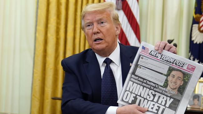 President Donald Trump holds up a copy of the New York Post before signing an executive order aimed at curbing protections for social media giants. Picture: AP