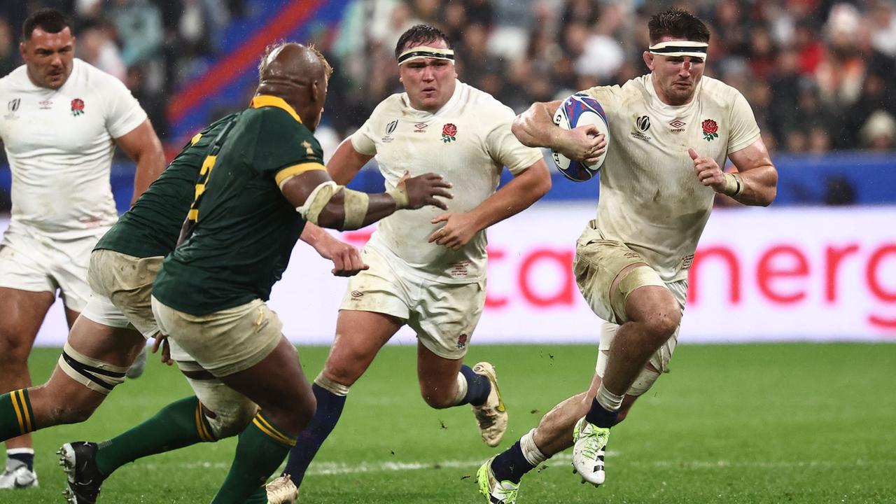 England's openside flanker Tom Curry (R) runs with the ball during the France 2023 Rugby World Cup semi-final match between England and South Africa at the Stade de France in Saint-Denis, on the outskirts of Paris, on October 21, 2023. (Photo by Anne-Christine POUJOULAT / AFP)