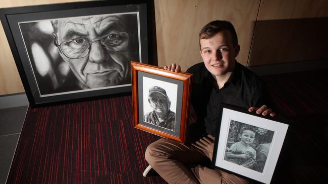 Travis Goodshaw, 18, with some of his artworks.