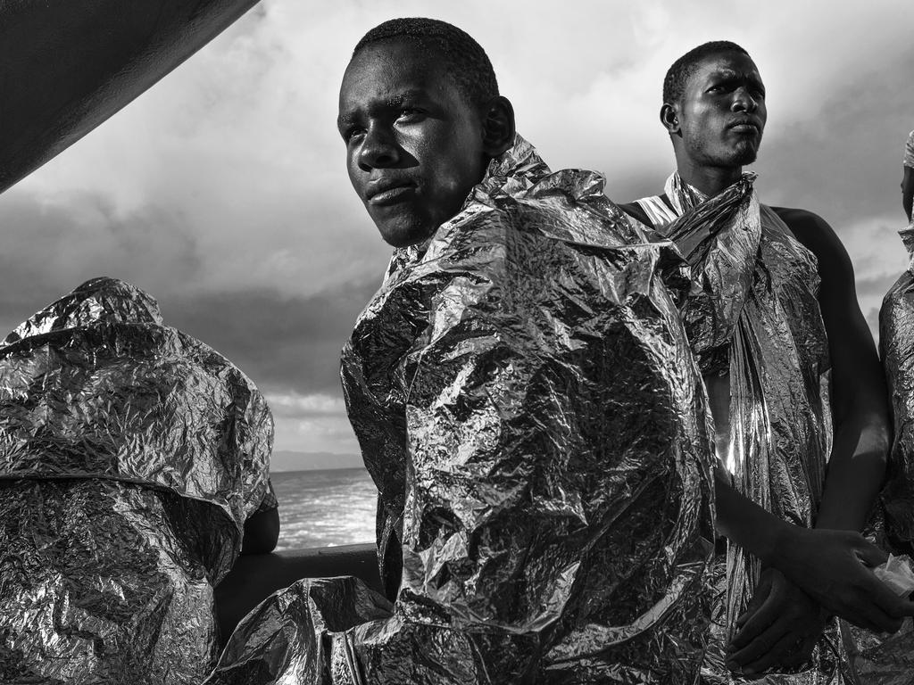 “In the Same Boat” by photographer Francesco Zizola for Noor agency which won the second prize in the Contemporary Issues category shows migrants wrapped in emergency blankets two days after being rescued catch sight of the Italian coast for the first time, Strait of Sicily, Mediterranean Sea, Aug. 23, 2015. (Francesco Zizola/Noor, World Press Photo via AP)