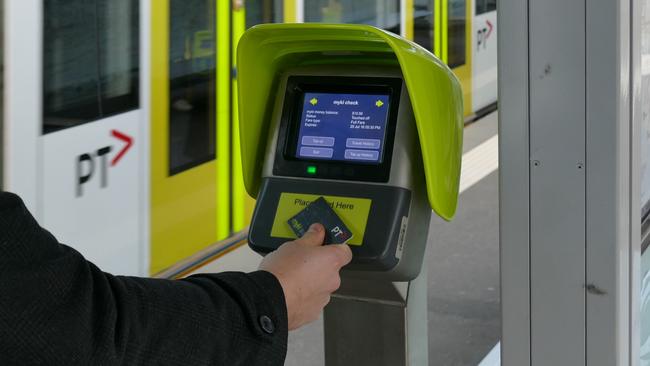 A passenger uses a Myki Quick Top Up machine at Domain Interchange.