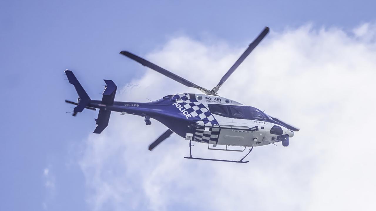 The Polair helicopter flies laps over Gilston in search of three alleged armed robbers on the loose. Photo: Luke Sorensen