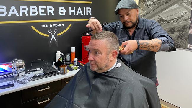 Bartons Motors managing director Mark Beitz getting a haircut at the company’s new barber shop.