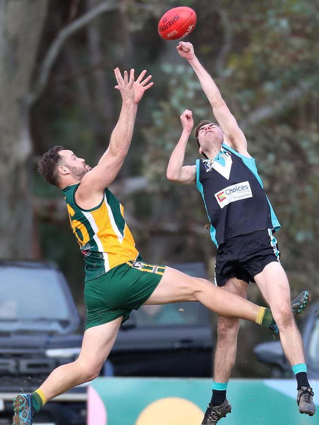 Murchison-Toolamba’s Michael Coad arrives late to spoil Dookie United opponent Aaron Lynn.