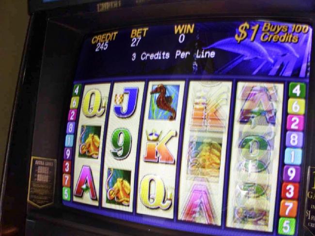 11/07/2002 LIBRARY: Generic photo of person playing poker machine. Hands holding money cup and placing money into machine. gambling pokies.